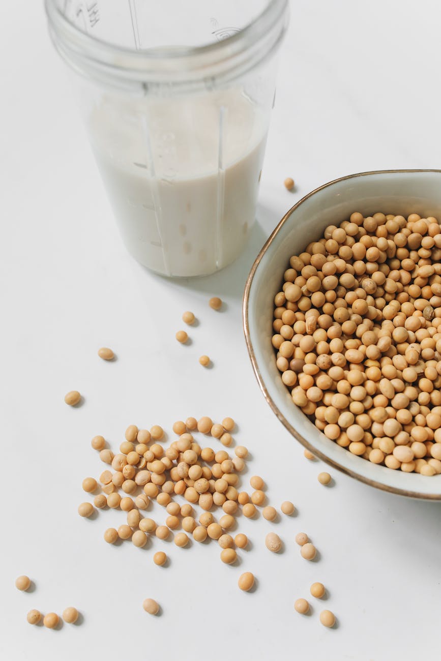 photo of soybeans near drinking glass with soy milk