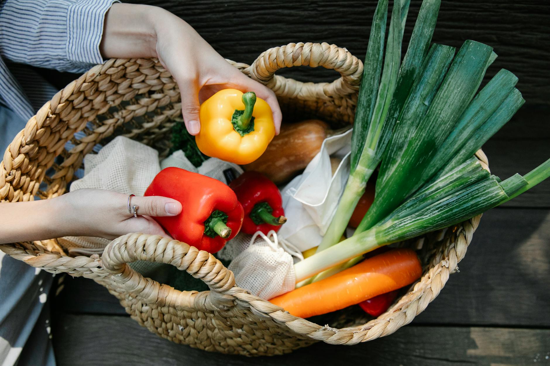 crop unrecognizable woman placing ripe vegetables in wicker basket