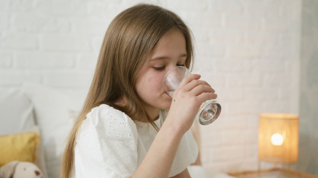 a girl drinking from a glass